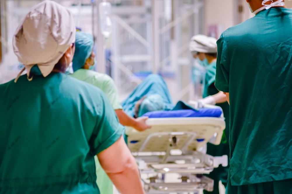 Doctors walking with patient on a gurney through the hospital